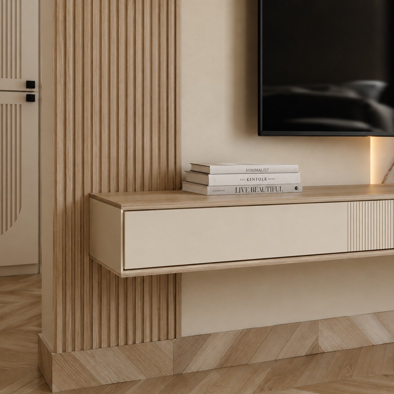 Close up of the console below the television: a floating cream drawer
                  unit set into fluted timber, books stacked on top, herringbone
                  flooring running beneath.