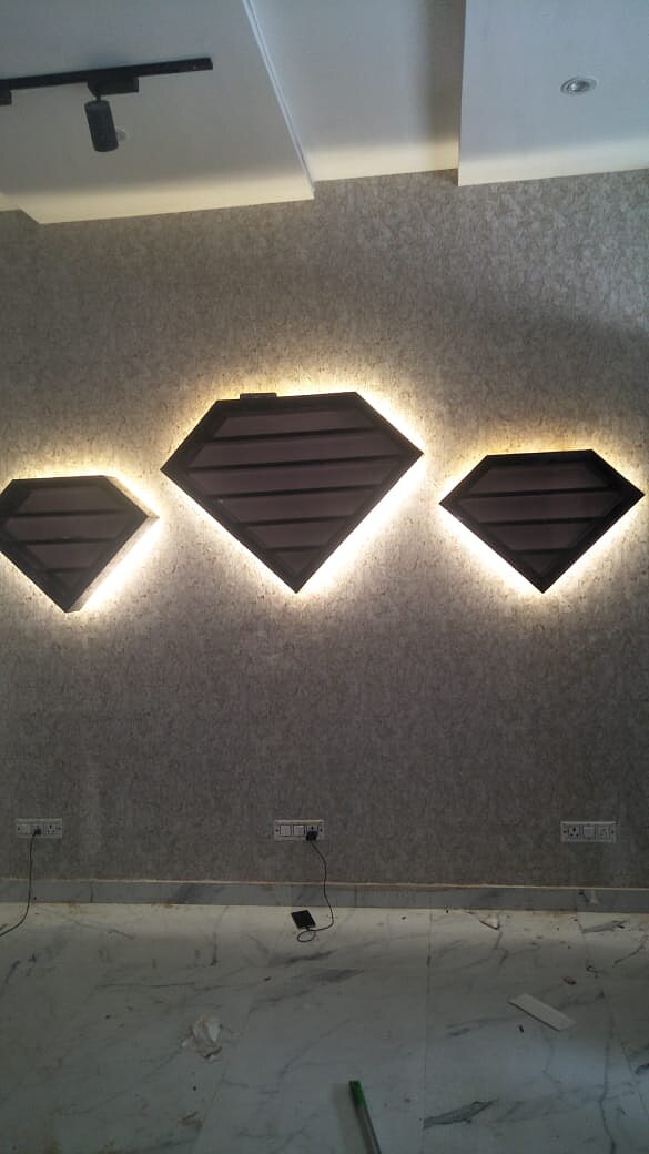 Two lit niches set into a grey wall, wired and tested before the finishes went on.