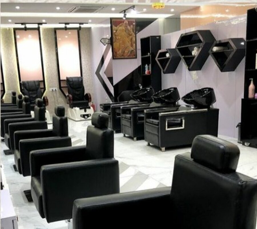 The finished salon: styling and wash stations in black leather down a marble floor, with hexagonal niches on the wall behind.