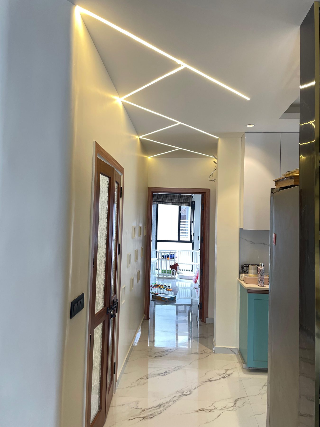 The corridor: a continuous line of light cut into the ceiling,
                  running past the doorways towards the daylight at the far end.