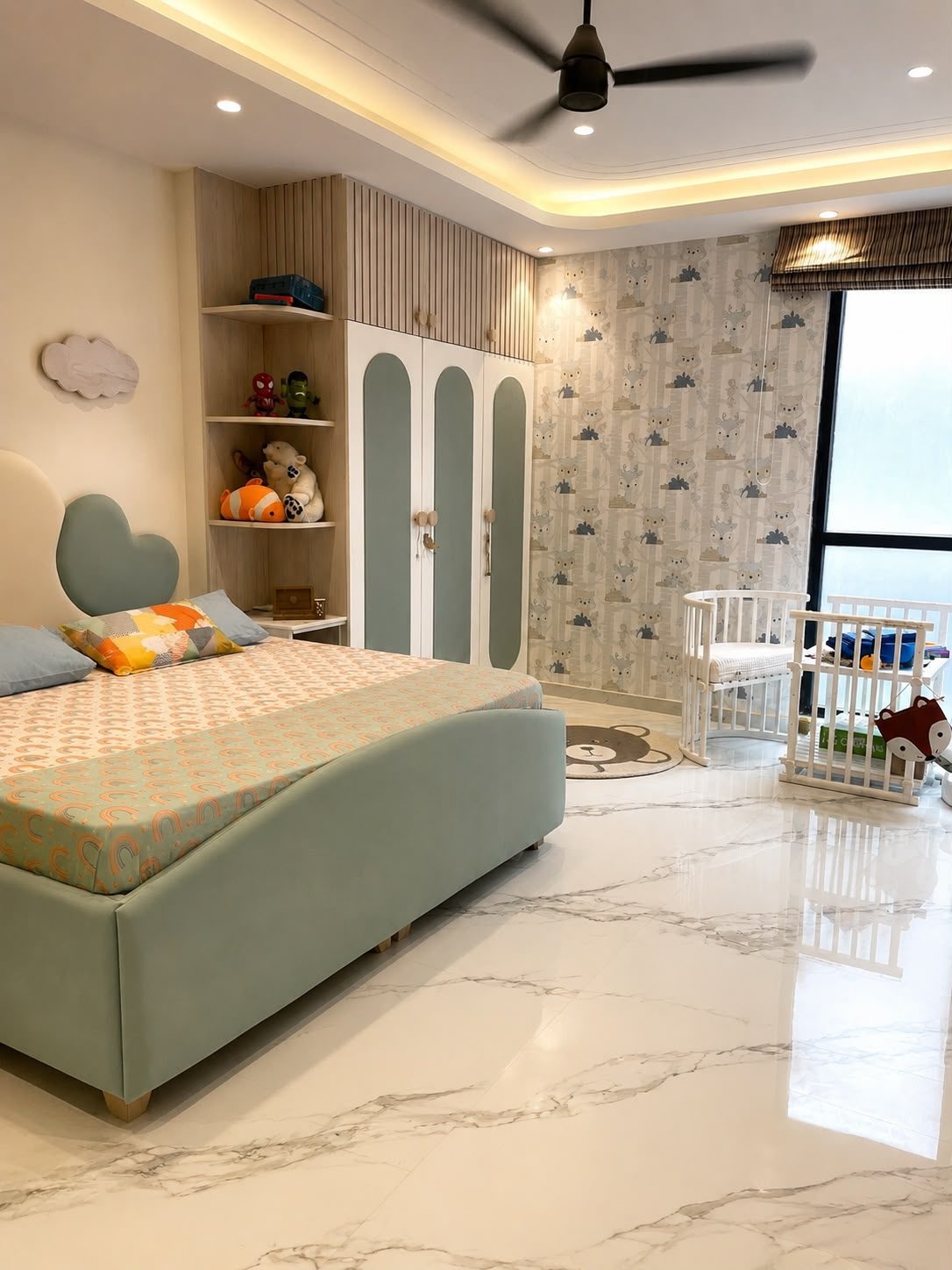 The children's room: a mint upholstered bed, cloud-shaped open
                  shelving holding toys, patterned wallpaper and a marble floor.