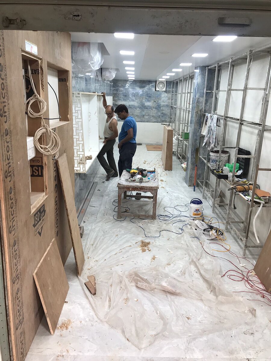 The unit before work started: bare walls, exposed wiring and dust sheets over the floor.