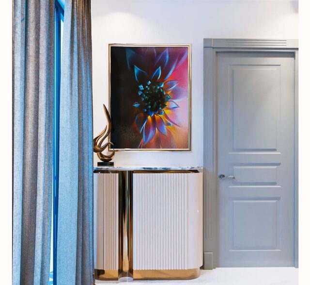 An entrance vestibule: a teal curtain, a fluted console and a large floral canvas.