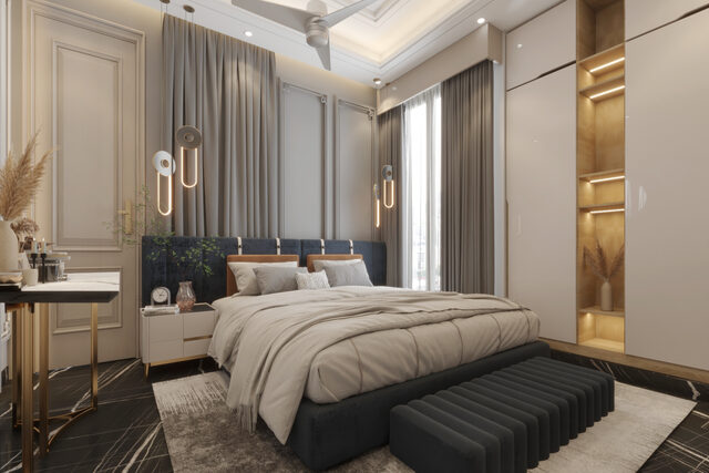 A bedroom in grey and blush: a tall headboard, pampas grass and a bench at the foot.