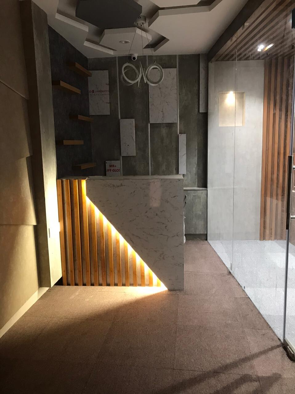 The reception counter, its slatted front lit from behind so the desk appears to float.