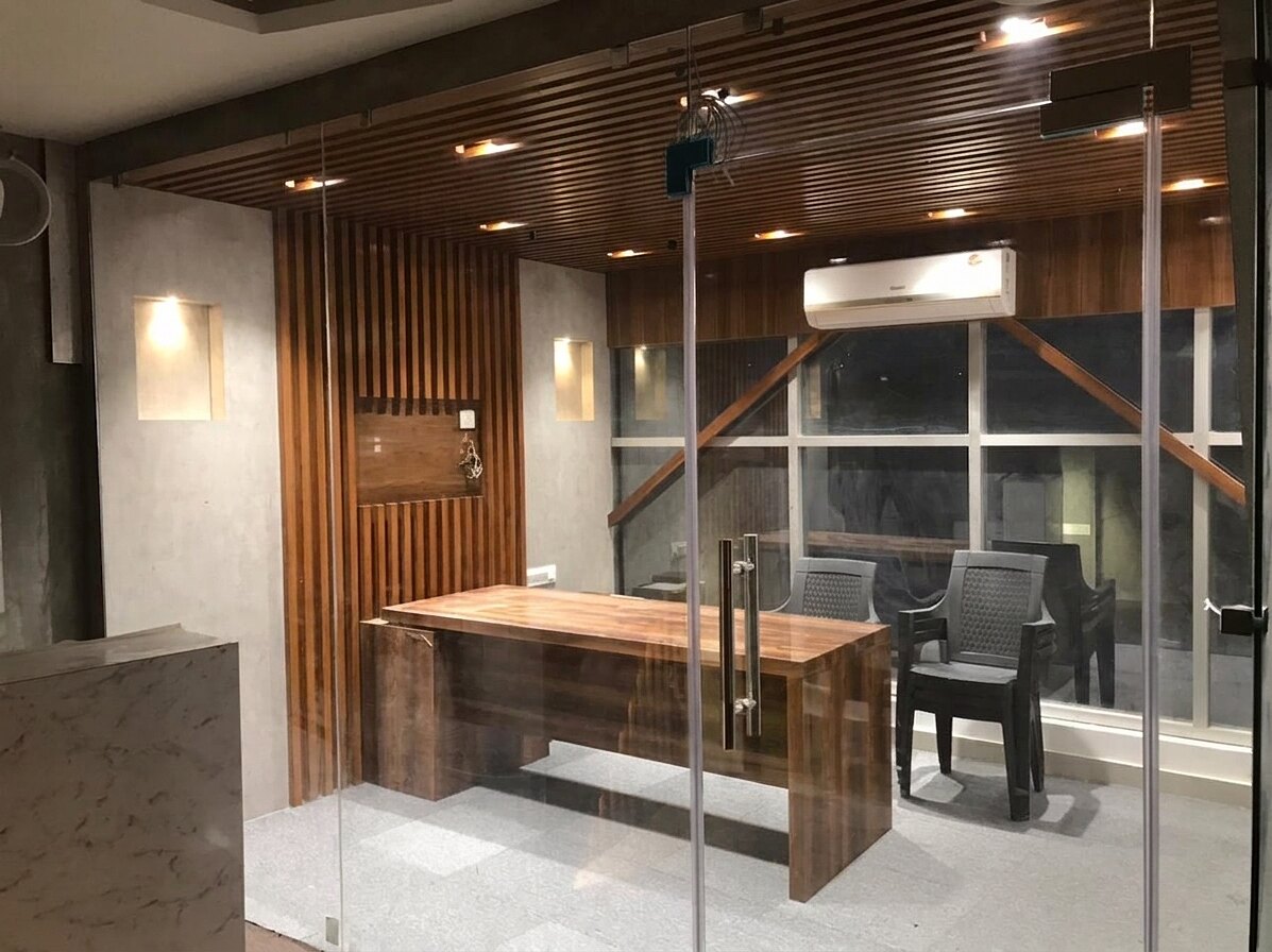 The managing director's cabin: a timber desk under a slatted ceiling, glazed to the corridor.